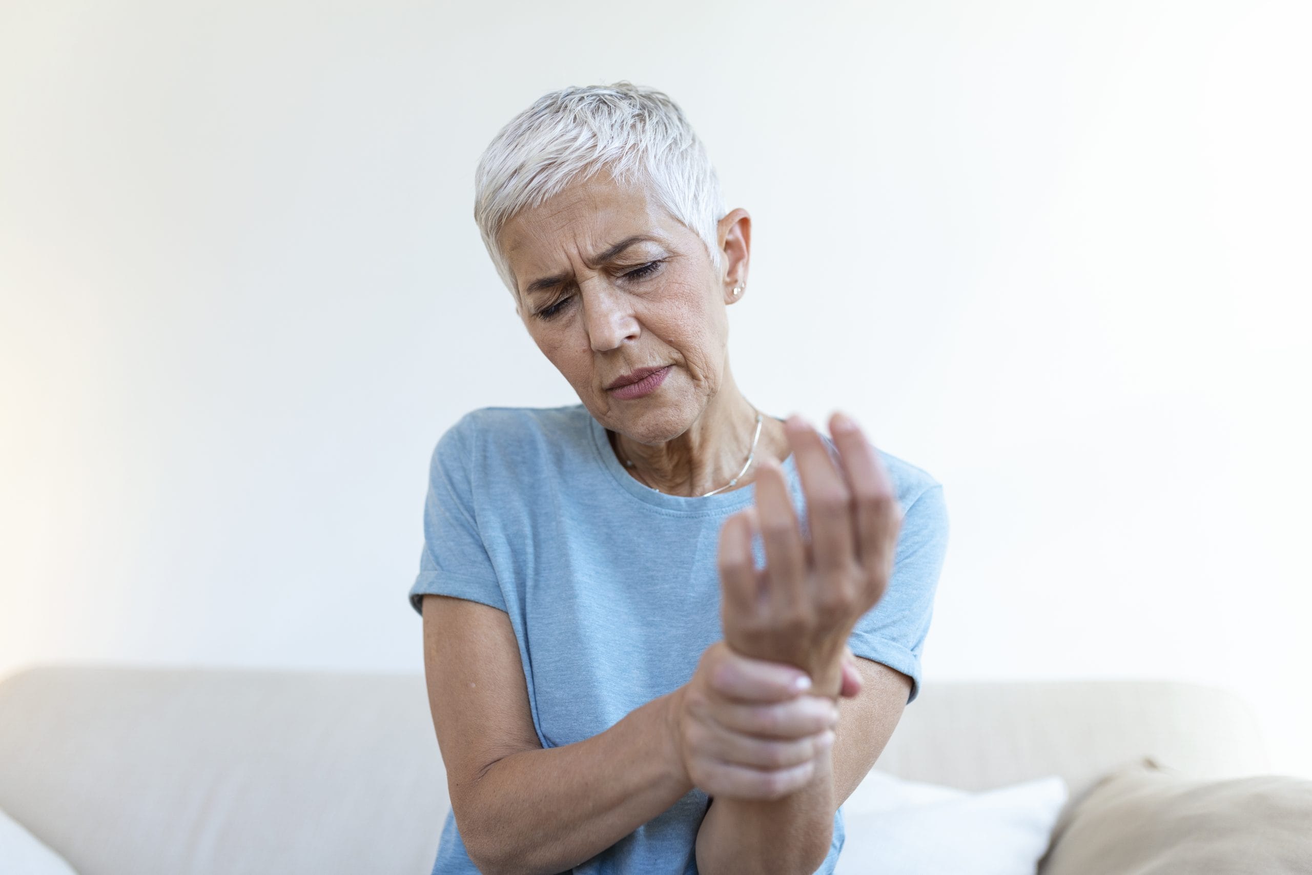 Femme d'une cinquantaine d'années qui se masse le poignet, douleurs articulaires liées à la ménopause